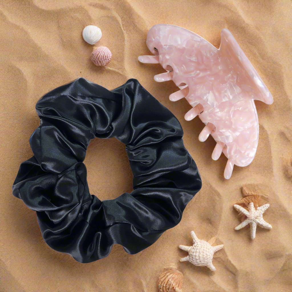 Mum’s Everyday Luxury Set – 22 momme oversized Mulberry Silk scrunchie and eco-friendly claw clip gift set on a beach with sand and sea shells.