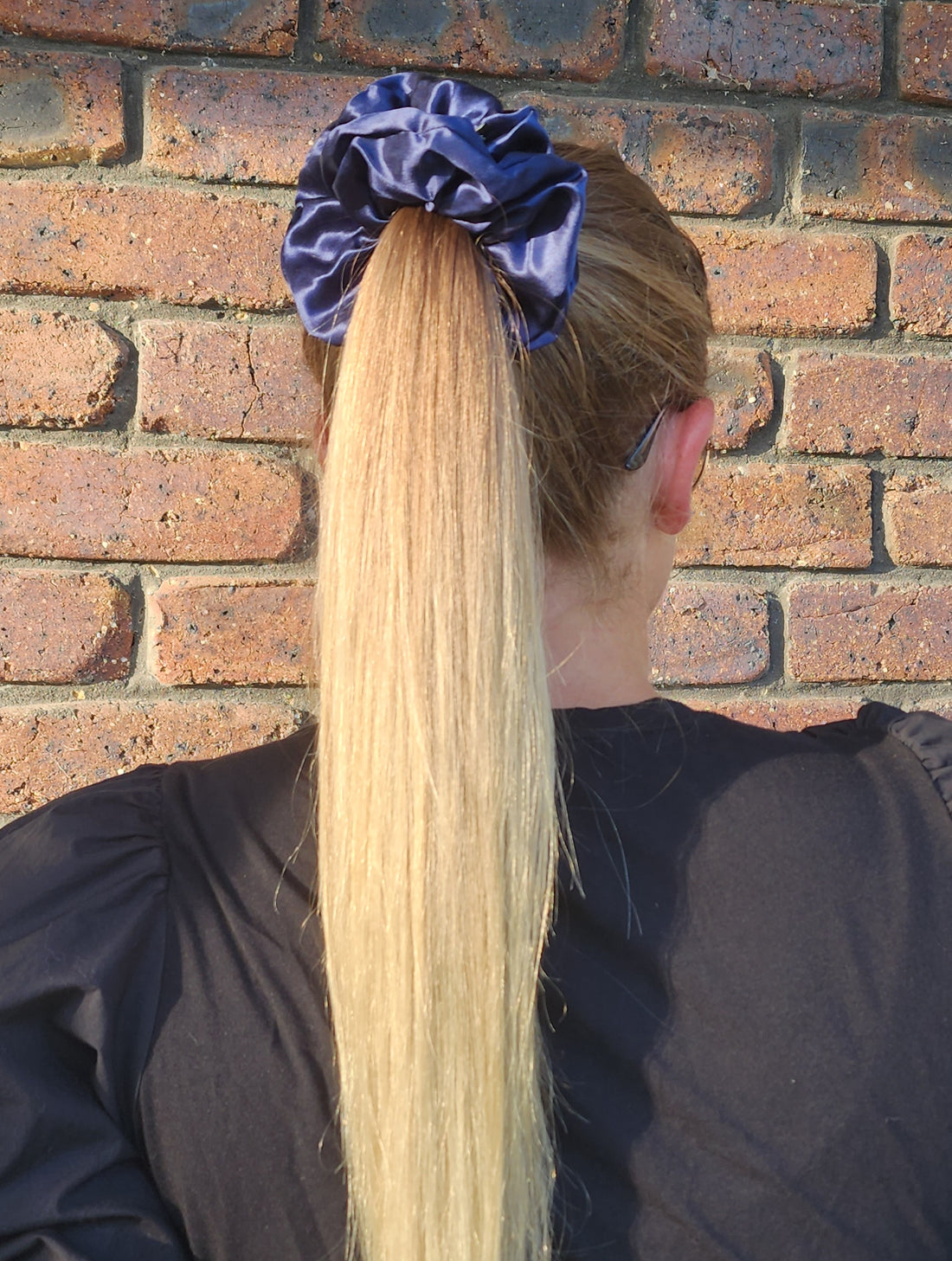 Midnight Tide oversized mulberry silk scrunchie in navy blue worn in a blonde ponytail outdoors