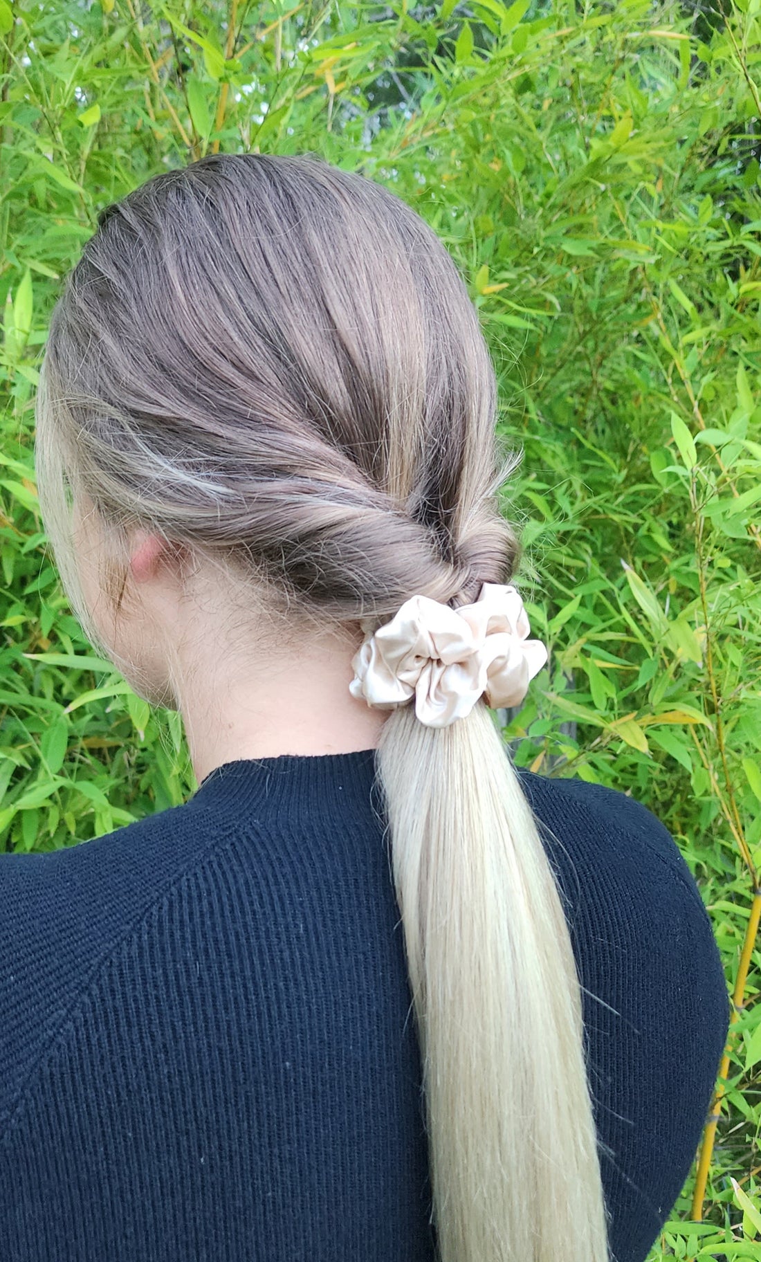 Oat Milk classic mulberry silk scrunchie in beige cream worn in a blonde ponytail outdoors