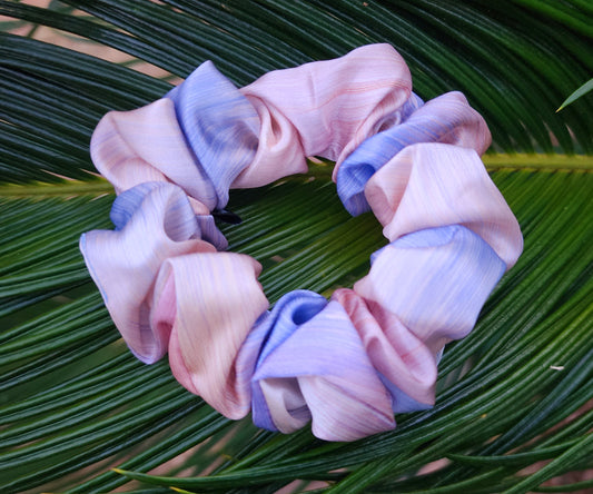 Daydream classic mulberry silk scrunchie in pastel blue, pink and cream resting on green palm leaves